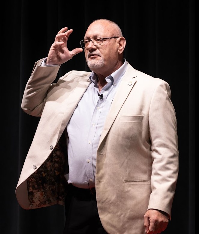 Bill Schuhlein speaking on stage