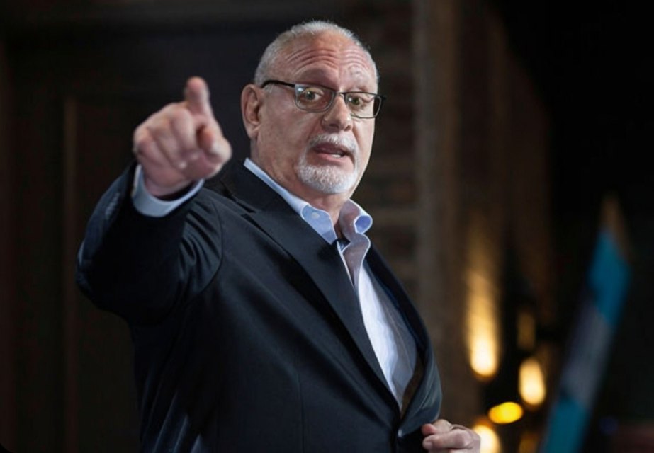 Bill Schuhlein pointing toward the audience during a keynote